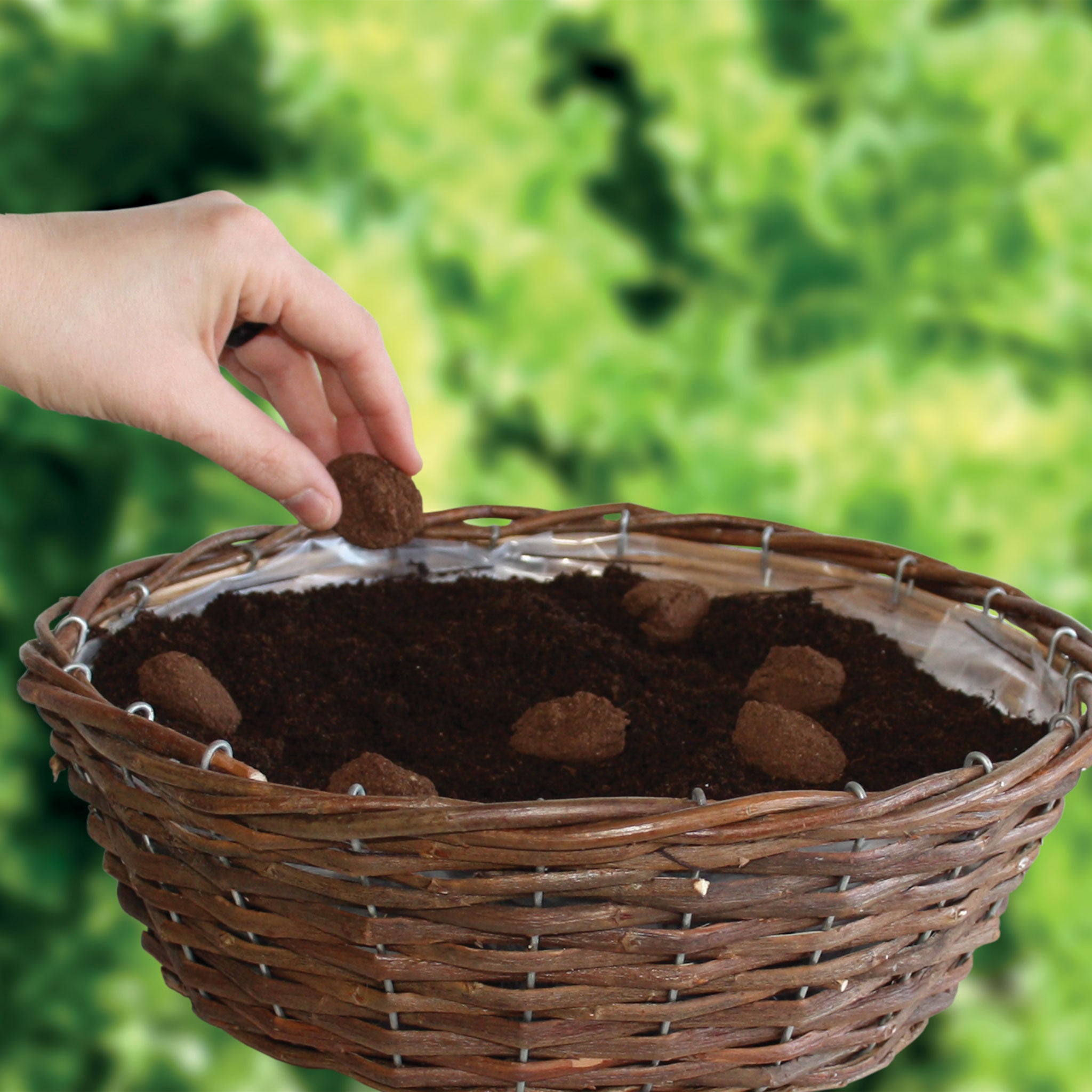 Hand placing seed bombs into a wicker flower basket