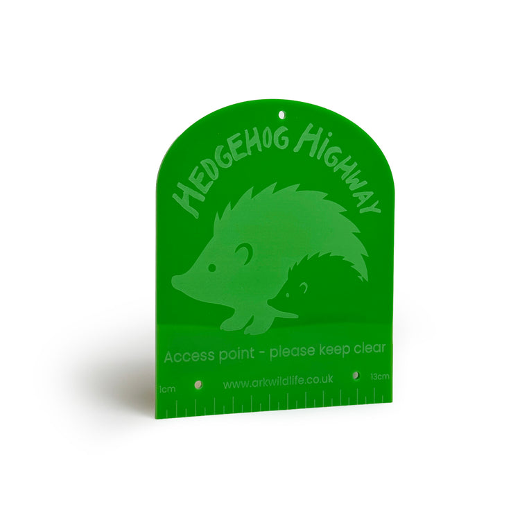 Green sign with hedgehog illustration and 'Hedgehog Highway' text on a white background